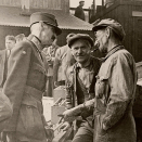 Kong Haakon i samtale med to verftsarbeidere i Buckie, Skottland. Foto: Asbjørn Barlaup, De kongelige samlinger